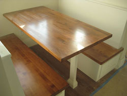 A booth in a kitchen with dark wooden tops