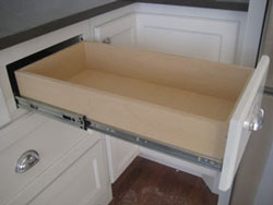 White kitchen cabinetry with an open drawer