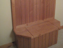 A wooden coatrack with space to sit and storage in the seat